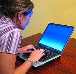 Mujer con su ordenador en un lugar público. Un ejemplo de la importancia que puede tener una conexión VPN. 