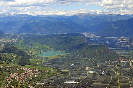 Überetsch mit dem Kalterer See aus südlicher Richtung mit Altenburg, Söll und Tramin links im Foto. Hinter dem Mitterberg die Etsch und Bozen (Fotobeschreibung)