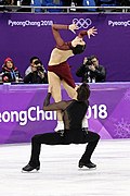 Pary taneczne – partner w pozycji besti squat przy podnoszeniu po łuku (Tessa Virtue / Scott Moir)