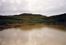 Foto dari reservoir dengan bukit di latar belakang
