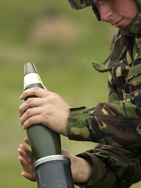 File:A Gunner prepares to release a Mortar round into the tube in readiness to fire. MOD 45144835.jpg