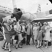 Jean Marais, photographié au milieu de la troupe des Blue Bell Girls du Lido de Paris, arrivant à l'aéroport d'Amsterdam-Schiphol le 13 avril 1965.