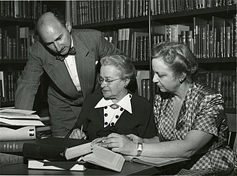 Landscape photo showing researcher Alfred Kinsey with two unidentified women in a library