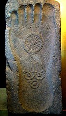 The Triratna or "Three Jewels" symbol, on a Buddha footprint (bottom symbol, the top symbol being a dharmachakra). 1st century CE, Gandhara.