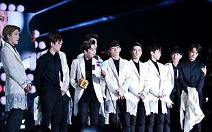 Exo debout sur scène recevant un prix aux Mnet Asian Music Awards en 2014