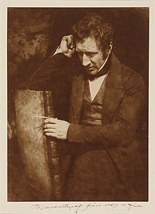 Retrato de James Nasmyth sentado de lado em uma cadeira com o braço apoiado a cabeça.