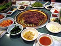 pulgogi (bulgogi)étterem: középen a pulgogi (bulgogi)grill, körben a köretek és szószok, például kkaktugi (kkakdeugi) (retekkimcshi (kimchi)) és sszamdzsang (ssamjang)