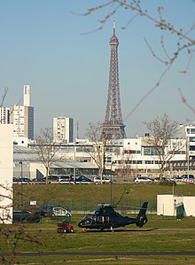 A Eurocopter AS365 Dauphin taking off from the heliport, with the Eiffel Tower behind. Lfpi.jpg