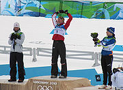 Marit Bjoergen (Norway) celebrates winning silver, Justyna Kowalczyk (Poland) gold and Aino-Kaisa Saarinen (Finland) bronze during the flower ceremony at the 2010 Vancouver Winter Olympics (27 February 2010)