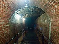 A section of aqueduct with brick walls and exposed ceiling