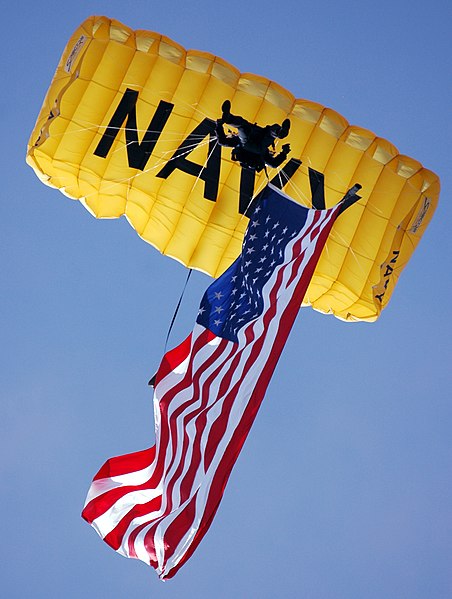 File:US Navy 070308-N-4163T-356 A member of the U.S. Navy Parachute Demonstration Team Leap Frogs descends into San Diego's Qualcomm Stadium with the American flag during a training session.jpg