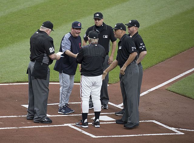 An MLB umpiring crew meeting with the managers from each team before a 2017 game