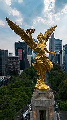 A “Vitória Alada” é uma escultura representando Niké que coroa o monumento.