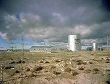 The ALPR before the accident. The large cylindrical building holds the nuclear reactor embedded in gravel at the bottom, the main operating area or operating floor in the middle, and the condenser fan room near the top. Miscellaneous support and administration buildings surround it.