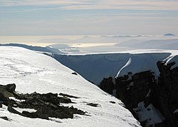 Vista al suroeste desde la cima a principios de abril. Cuando los bordes de los acantilados tienen cornisas, el correcto desplazamiento es indispensable.