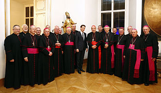 Van der Linde, 7th from the right, stands behind Cardinal Schonborn. Bischofskonferenz Sebastian Kurz 2014 (15716466865).jpg