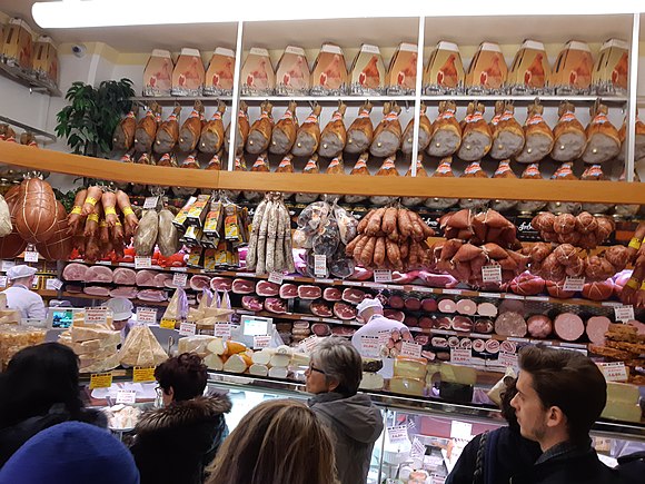 Display of hams, pig's trotters, salamis, and mortadella in a pork butcher's shop, Bologna, Italy