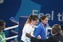 Governing body representatives attend the events to ensure compliance with the rules and congratulate the finalists Boxing at the 2018 Summer Youth Olympics - Girls' flyweight Victory Ceremony 082.jpg