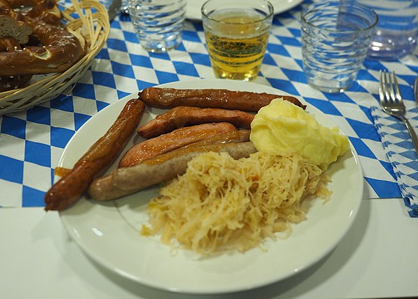 A plate of bratwurst, sauerkraut and mashed potatoes, typical of German cuisine