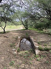 A section of a compuerta (holding area) and historic acequia in Tumacacori National Historical Park, Santa Cruz County, Arizona The trail beyond the compuerta is the original route of the acequia.