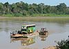 A ferry carrying a bus and passengers across Río Beni