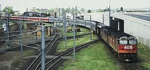 44216 and another haul the northbound Brisbane Limited across the Corinda line at Yeerongpilly in 1987 Dia 0216.jpg