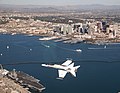 F/A-18 Hornet volant au-dessus de San Diego. L'USS John C. Stennis est visible.