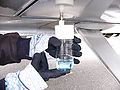 Taking a fuel sample from an American Aviation AA-1 Yankee under-wing drain using a GATS Jar fuel sampler. The blue dye indicates that this fuel is 100LL.