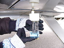 Taking a fuel sample from an under-wing drain using a GATS Jar fuel sampler. The blue dye indicates that this fuel is 100LL. GATS jar 03.JPG