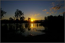 Peter Neaum (nd) Photographie couleur silhouette du lever du soleil sur les eaux réfléchissantes du lac Mournpall, entouré de broussailles basses, parc national Hattah-Kulkyne.