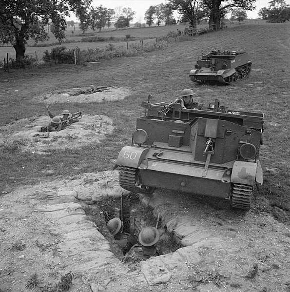 Universal carriers 'attack' men of the 10th Battalion, Royal Berkshire Regiment defending from slit trenches during training near Sudbury, Suffolk, 10