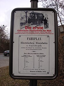 A photo of a plaque raised in Lichterfelde, Berlin, Germany, to mark the world's first electric streetcar line. The plaque is located on a stand near the Lichterfede Ost Railway Station in Berlin, Germany. The plaque marking the Gross Lichterfelde Tramway.JPG