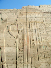 Depiction of Tuthmose III at Karnak holding a Hedj Club and a Sekhem Scepter standing before two obelisks he had erected there ThutmosesIII-RaisingObelisks-Karnak.png