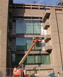 Les travailleurs d'un ascenseur remplacent les fenêtres de la façade est du bâtiment Yale Art + Architecture.