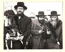 הרב שמואל אלכסנדר אונסדורפר בצד שמאל מחזיק ספר תורה ולידו השפע חיים מצאנז
