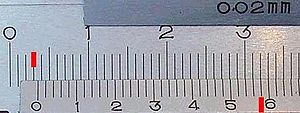 Vernier caliper scales; main at top, vernier at bottom. It reads 3.58 +- 0.02 mm by adding 3.00 mm (left red mark) on the fixed main scale to vernier 0.58 mm (right red mark). The main scale reading is that to the left of the zero on the vernier scale. The vernier reading is found by locating the best aligned lines between the two scales. The 0.02 mm engraving indicates the caliper's readability and is the "vernier constant" for this scale. Close up of vernier scale.jpg