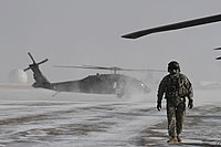 A Colorado Army National Guard crew chief conducts preflight checks on a UH-60 Black Hawk helicopter during a blizzard response exercise. Colorado National Guard (23688721303).jpg