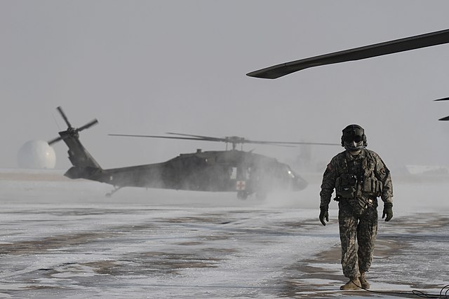 A Colorado Army National Guard crew chief conducts preflight checks on a UH-60 Black Hawk helicopter during a blizzard response exercise