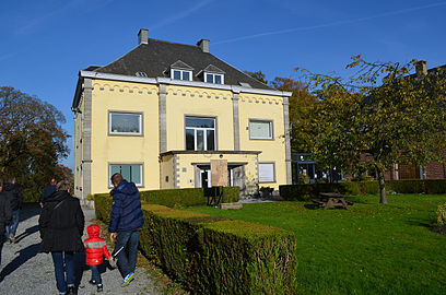 Gebouw dat lijkt op een villa met vier geel geverfde gevels in een park.