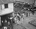 Crowd of men and women on wooden dock (3796293628).jpg