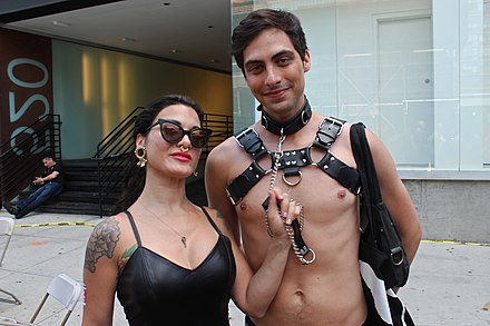 A D/s couple posing for a picture. Many submissives wear a collar to denote their status and commitment.