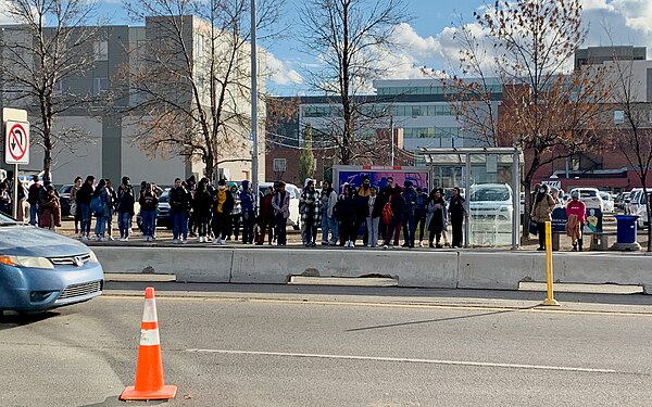 Crowd at an ETS bus stop around MacEwan University during the afternoon rush hour