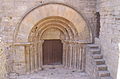 Portal romànic amb arc de mig punt abocinat i amb l'extradós remarcat a l'església de Forès, a la Conca de Barberà.