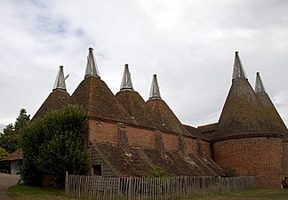 Oast houses at Sissinghurst Castle, Kent, used for drying hops for beer. The two on the right are of the usual conical type. Early 19th century.