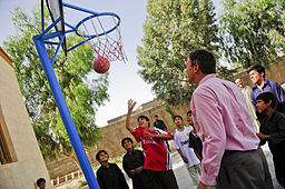 USA:s ambassadör ser på när några barn spelar basket i Farah.