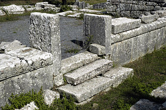 On either side of a doorway, the wall of the Temple of Despoina at Lycosura has a course of orthostates with string courses above them Lycosoura-orthostates.jpg