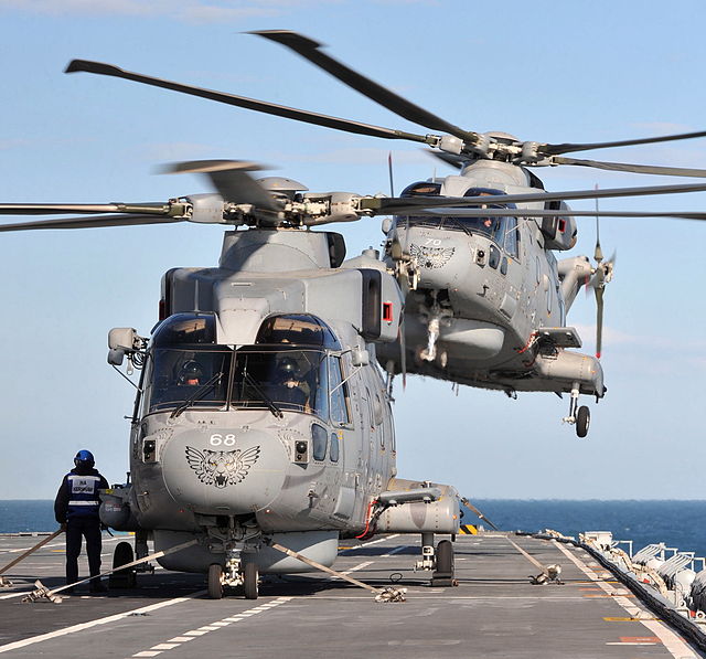 Two AgustaWestland Merlin HM2 of 814 NAS landing on HMS Illustrious during Exercise Joint Warrior in 2012. Note the tiger markings on the aircraft nos