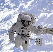 The pale blue Earth serves as a backdrop for astronaut Michael Gernhardt, who is attached to the Space Shuttle Endeavour's robot arm during a spacewalk on the STS-69 mission in 1995.