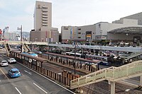 長崎車站前電車站，後方為車站前人行天橋廣場及商場AMU PLAZA長崎館