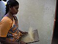 箕を使って米をより分ける、南インドのタミル人女性／2011年撮影。